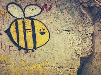 Graffiti einer Biene auf Steinwand